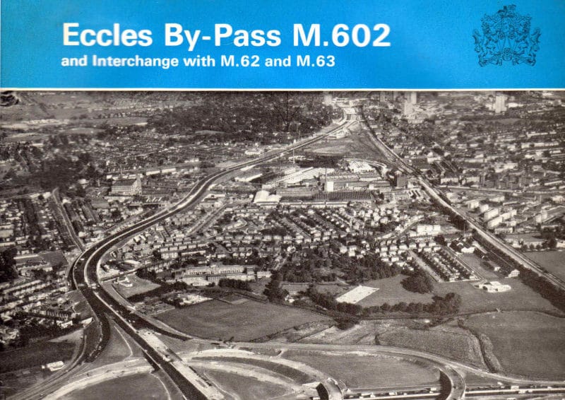 Front cover of a booklet with the title "Eccles By-Pass M602", with a black and white aerial photograph of a motorway and a large interchange under construction in an urban area