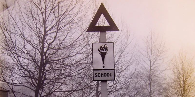 A wooden prototype 'school' sign, with the obscure torch symbol. Click to enlarge