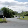 At College Place roundabout, the B5210 is to our left, running parallel to the M6 and providing access to large industrial and residential zones. The direction sign here is original to the New Town development and has its signature boxy construction. Beyond, Birchwood Way climbs back up to join the non-existant flyover.