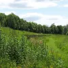 Along the next section we're back to single carriageway again. This view looks west along the line of the road - Birchwood Way is on top of the embankment to our left. There's a huge area of empty land for the unbuilt dual carriageway and eastbound sliproad.