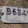In the North East of England, you can still find your way to Wooler in the dark with this handsomely reflectorised old sign.  Photo by John Neesom