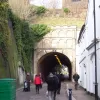 Pass between the shops and the tunnel itself is immediately visible just a few paces further on. It's still not much more than a wide path, but until about 1972 you could drive through here.